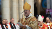 Archbishop Stephen Cottrell in gold robes and mitre addressing a congregation, as he is surrounded by seated bishops and clergy