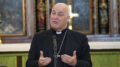The Archbishop of York Stephen Cottrell wearing a purple clerical shirt and dog collar with a suit
